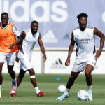 Real Madrid Face Scrutiny Over Dressing Room Atmosphere Ahead of El Clásico Questions have emerged over the internal environment at Real Madrid as the club prepares for El Clásico, with several reports suggesting a mixed atmosphere within the first-team squad. According to The Athletic, there is a sense of unease around the dressing room, with concerns raised about a lack of visible unity as the team approaches one of the most high-profile fixtures of the season. While preparations continue as normal, the report indicates that the overall mood has prompted discussion regarding squad cohesion. Despite these claims, other outlets present a more balanced picture regarding relationships between key players. Marca reports that Kylian Mbappé and Vinícius Júnior maintain a strong professional and personal relationship. The two forwards are said to share a good bond off the pitch, including spending time together socially with their partners, which contrasts with suggestions of internal division. Meanwhile, Diario AS reports that Real Madrid’s hierarchy retains complete confidence in its core stars, including Mbappé, Vinícius Júnior, and Jude Bellingham. The club reportedly views the trio as central to both the present and future of the team, with expectations that the coaching staff will be tasked with building a more structured and cohesive system around them. Off the pitch, Mbappé has reportedly been the target of racist abuse on social media, an issue that has drawn widespread condemnation across football. While not formally addressed in detail by the club, such incidents continue to raise concerns about player welfare and online abuse in the sport. At the same time, reports have also surfaced of an online petition from a section of supporters calling for Mbappé to leave the club, which has reportedly gathered a significant number of signatures. However, there is no indication that this reflects the official stance of Real Madrid or has any impact on internal planning. As El Clásico approaches, Real Madrid find themselves under both sporting and external pressure, with attention focused on how the squad responds on the pitch amid growing scrutiny off it.